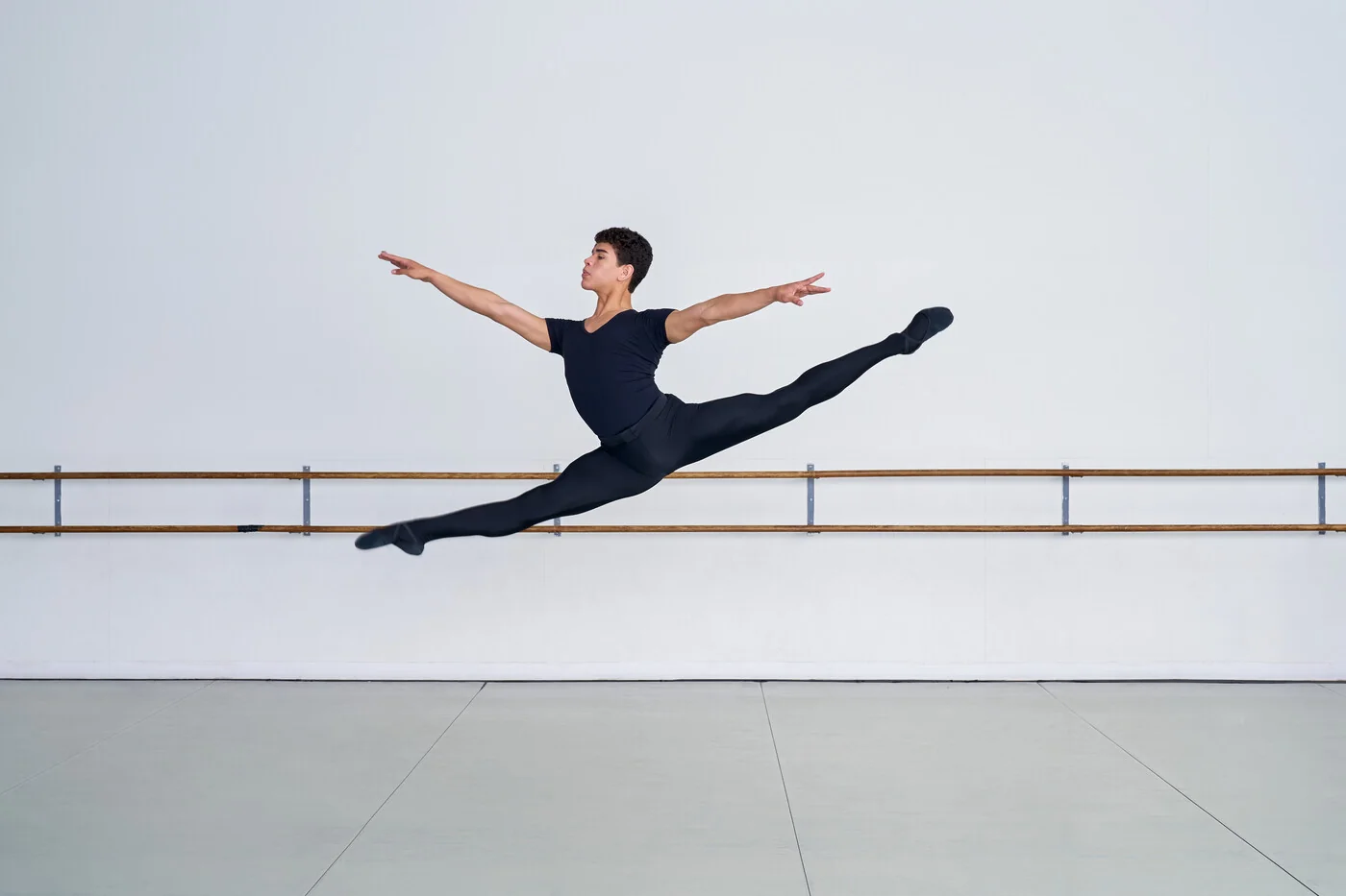 Alberta Ballet Schoolのスタジオで高くジャンプする男性ダンサー