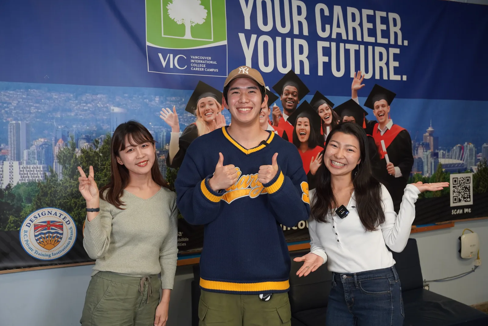 VICのポスターの前で笑顔を見せる3人