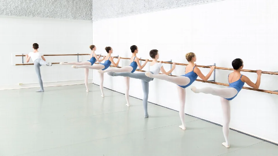 明るいスタジオでバー・レッスンを受けるAlberta Ballet Schoolの生徒たち