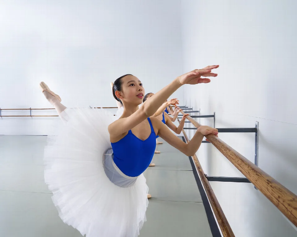 Alberta Ballet Schoolのバーでアラベスクを練習する生徒